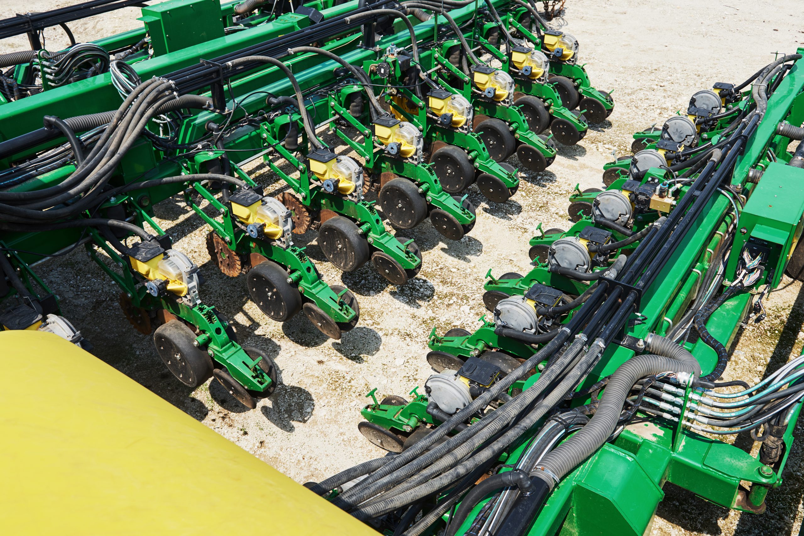 Close up of seeder attached to tractor in field. Agricultural machinery for spring works sowing, seeding